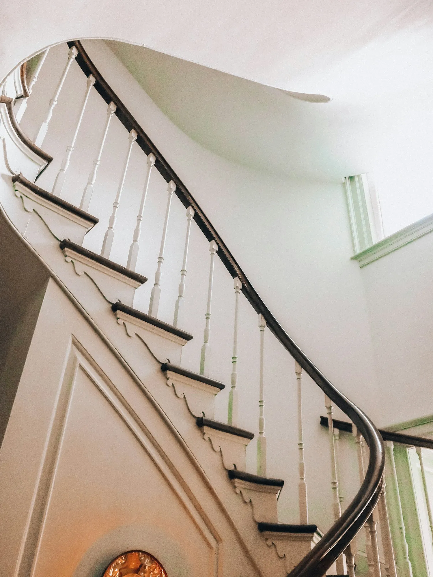 Elegant curved hardwood staircase with white balusters